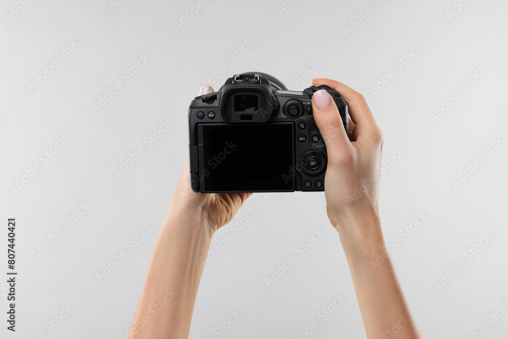 Fototapeta premium Photographer with camera on light grey background, closeup