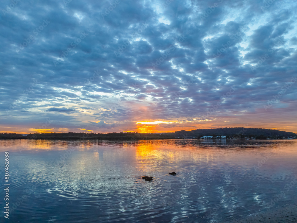 Fototapeta premium Sunrise over the bay water with clouds and reflections