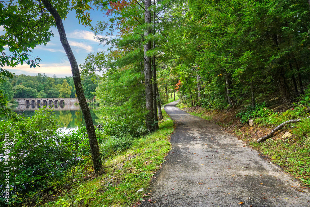 Byrd Lake Trail with a view of the sandstone bridge in Cumberland Mountain State Park in Tennessee. Paved ADA-accessible nature trail.