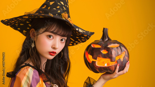 ハロウィンの仮装をした日本人の女性 オレンジ背景 photo