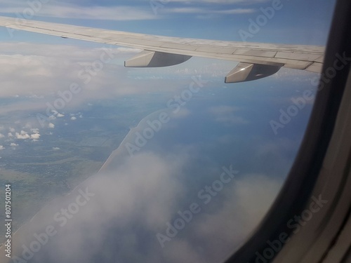 Looking through window aircraft during flight in wing with a nice blue clear sky and beautiful clouds. flying and traveling  view from airplane that can see outside.