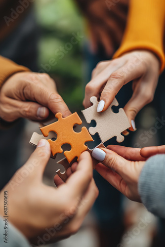 Closeup of hands holding puzzle pieces, symbolizing collaboration and teamwork in business or life. Business team concept with jigsaw puzzle