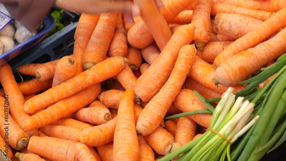woman hand pick fresh carrot from pile carrot displaying at super market woman hand pick fresh carrot from pile carrot displaying at super market