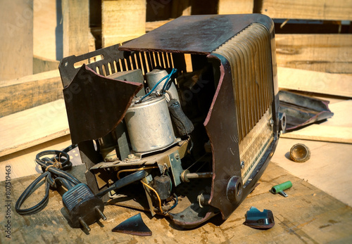 broken vintage ebonite tube radio, wooden pallet for packing at the background