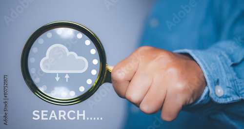 Businessman using magnifying glass search information network with cloud icon.