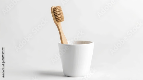 natural eco friendly toothbrush with wooden bamboo handle in a white cup