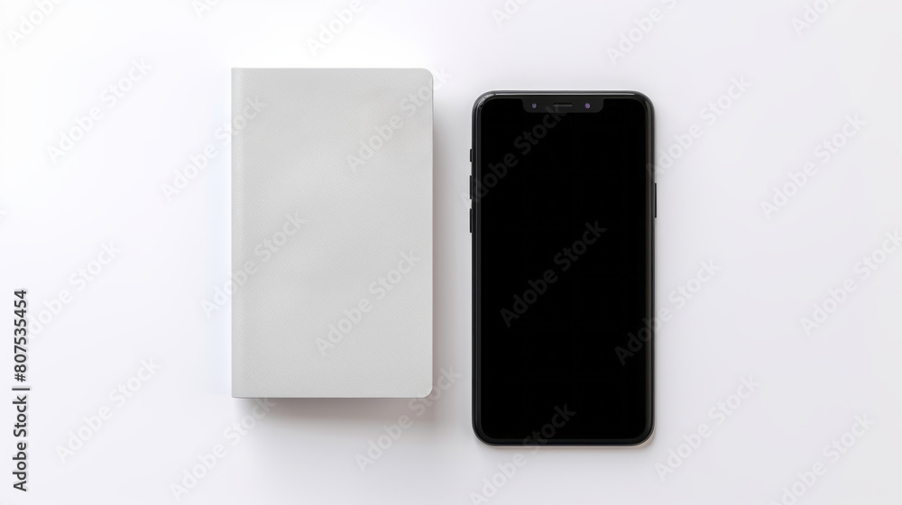 A sleek smartphone lies beside a closed light grey notebook on a white surface A sleek smartphone lies beside a closed light grey notebook on a white surface