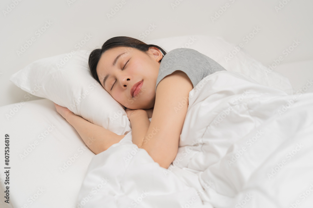 Sweet dreams, attractive smile pretty asian young woman, girl sleeping in comfortable bed lying on soft pillow resting, keeping eyes closed while with covered blanket in cozy white bed in the morning. Sweet dreams, attractive smile pretty asian young woman, girl sleeping in comfortable bed lying on soft pillow resting, keeping eyes closed while with covered blanket in cozy white bed in the morning.