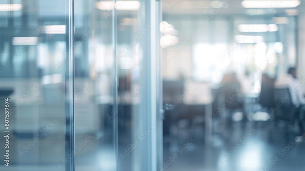 Blurred offices with people working behind glass walls