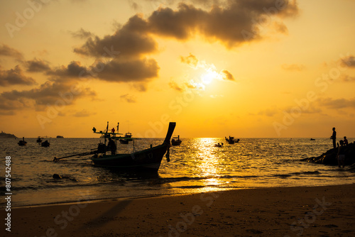 Sun and Boat at Kalim Beach at twilight time in summer Phuket Thailand