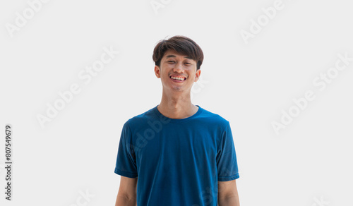 Young man in blue t-shirt smiling happily isolated on gray background. © Apirak