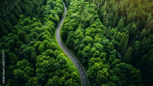 Green energy concept with an aerial shot of a forest road emphasizing sustainable travel through nature