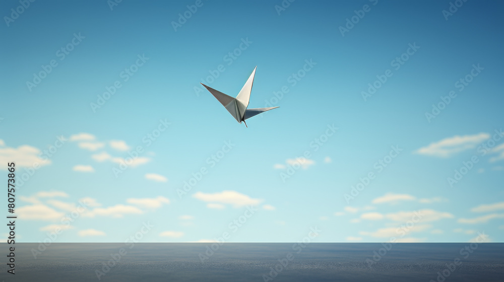 Fototapeta premium A paper bird is flying in the sky above a blue ocean