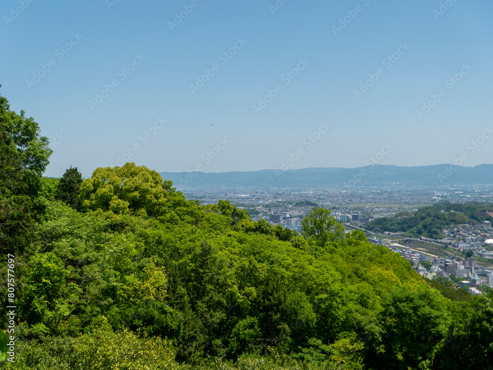 新緑に覆われた山と奈良盆地の街並み