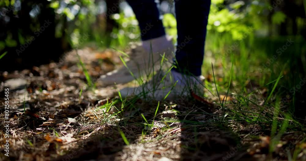 Woman throwing an empty beer glass bottle on the grass while walking in the forest Woman throwing an empty beer glass bottle on the grass while walking in the forest
