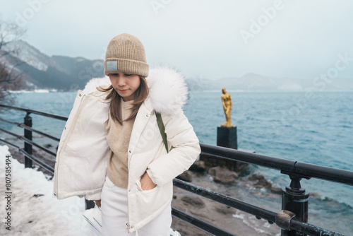 Woman tourist sightseeing golden Tatsuko statue and Lake Tazawa. Traveler travel in Semboku city, Akita Prefecture, Japan. Landmark for tourist attraction in Tohoku Region. Japan travel and vacation © Jo Panuwat D