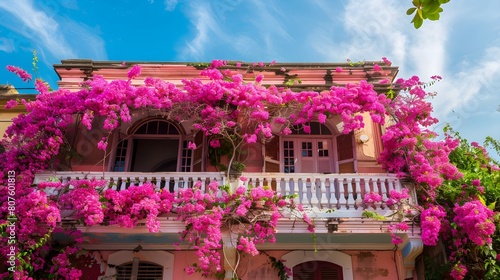 A charming building adorned with vibrant pink Bougainvillea flowers climbing its side, creating a picturesque and enchanting scene
