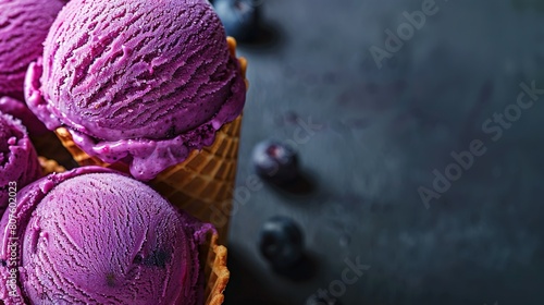   Three scoops of purple ice cream in a waffle cone with blueberries at the base