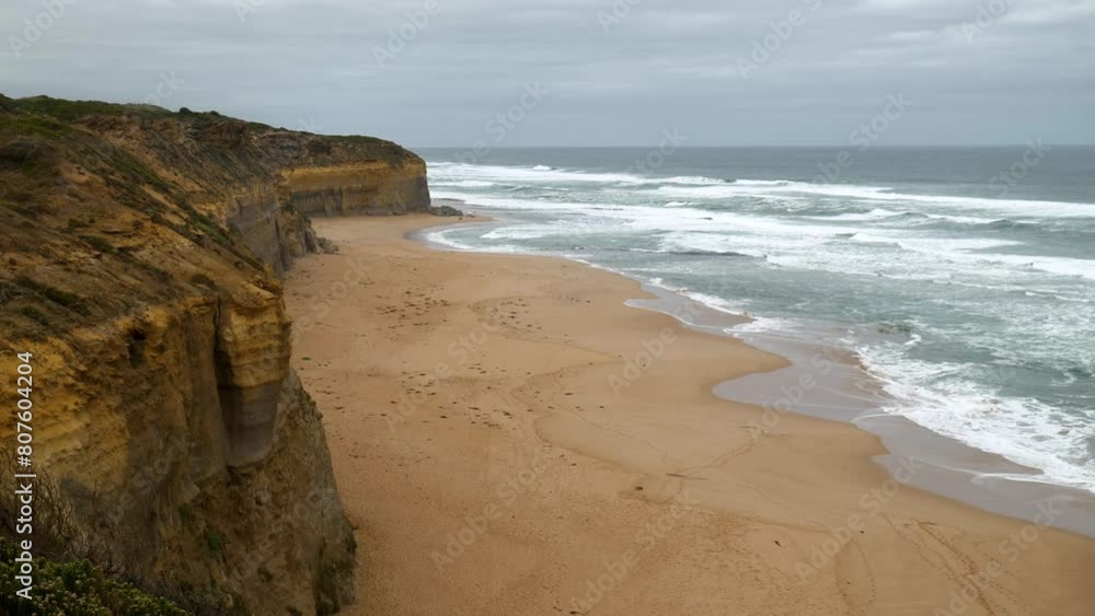 Wide shot of the serene Gibson Step Beach with its vast sandy expanse and tranquil waves. Wide shot of the serene Gibson Step Beach with its vast sandy expanse and tranquil waves.
