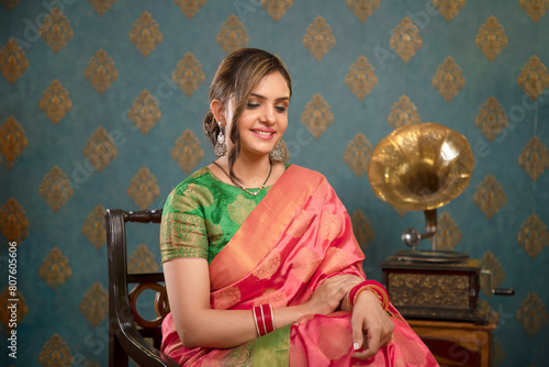 Stock Image Of A Beautiful Woman In Saree Posing For The Camera While Sitting On A Chair During The Diwali Festival
 photo