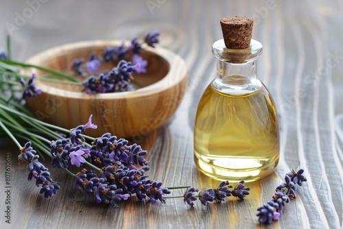 a bottle of oil next to a bowl of lavender