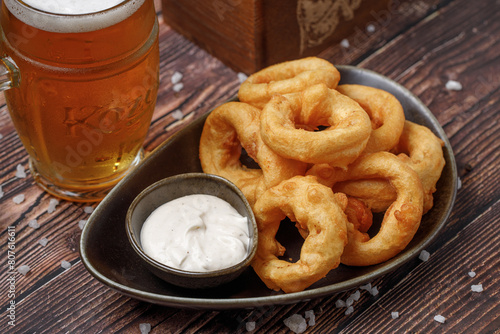 a plate of fried onion rings and a glass of beer