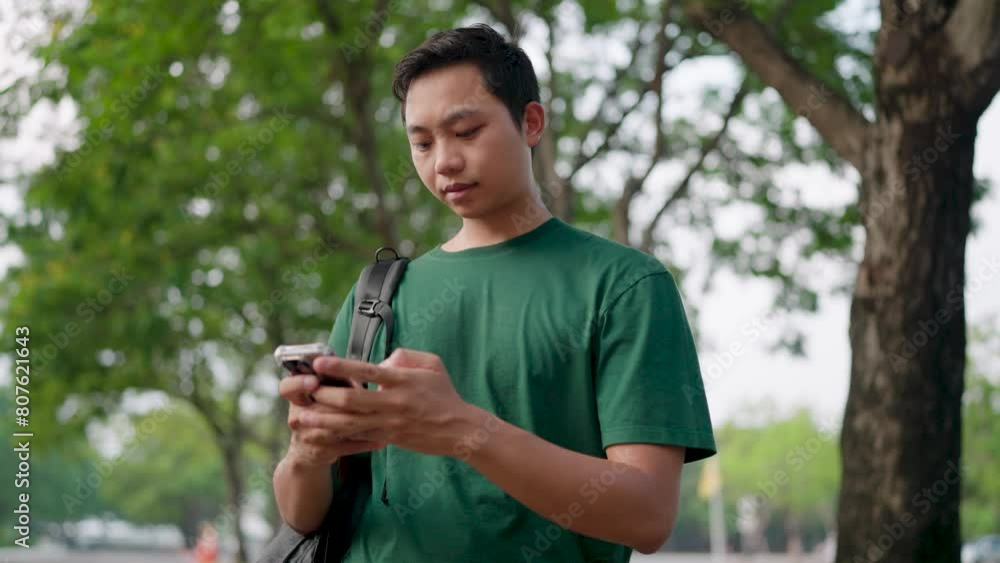 A man uses a phone to talk about work through an app. A man uses a phone to talk about work through an app.