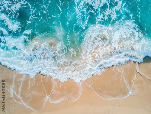 Sandy beach and blue ocean waves from above