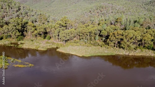 Tilt drone shot of lower Snowy River and mountain range in Kosciuszko National Park on summer day, NSW, Australia photo