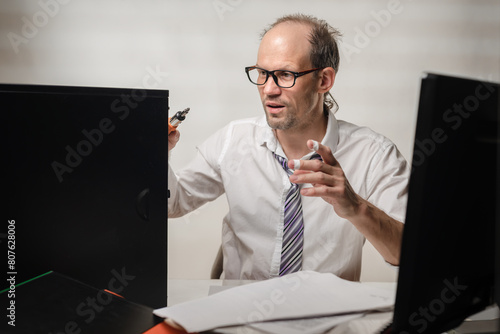 Unlucky young depressed man with band aid on fingers after office computer repair, Furious man takes on a computer breakdown with intensity.