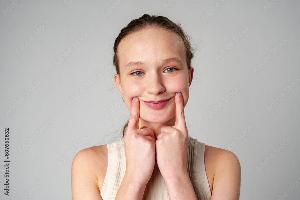 Young Woman Grimacing in Displeasure Against a Neutral Background Young Woman Grimacing in Displeasure Against a Neutral Background
