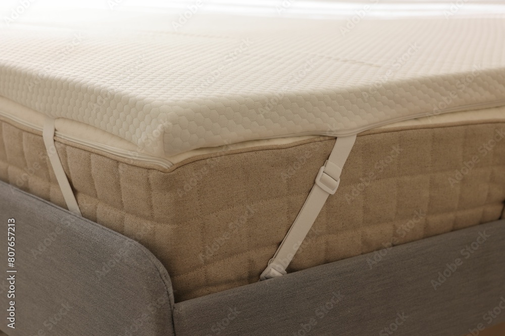 White memory foam mattress topper on grey bed, closeup White memory foam mattress topper on grey bed, closeup
