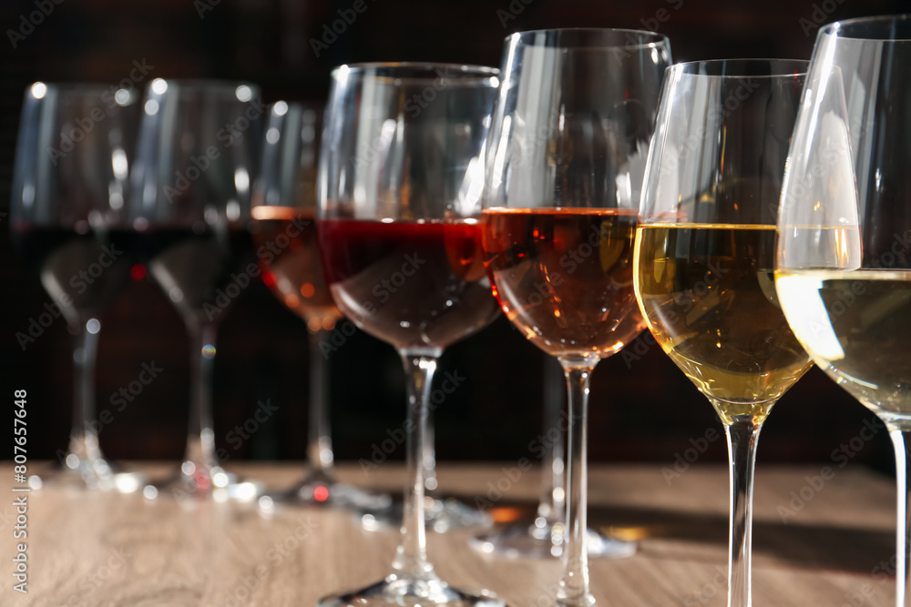 Different tasty wines in glasses on wooden table Different tasty wines in glasses on wooden table