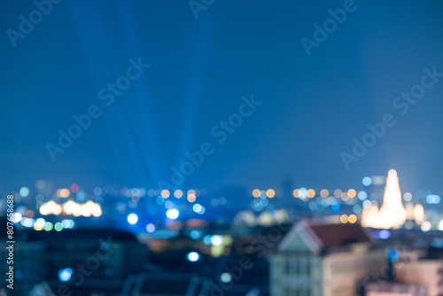 Abstract blurred background cityscape of Krung Thep Maha Nakhon (Bangkok) on night scene with multicolour bokeh from neon light on building photo