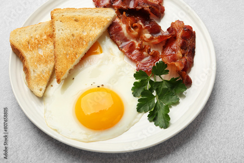 Fotografija Delicious breakfast with sunny side up egg on light table, closeup