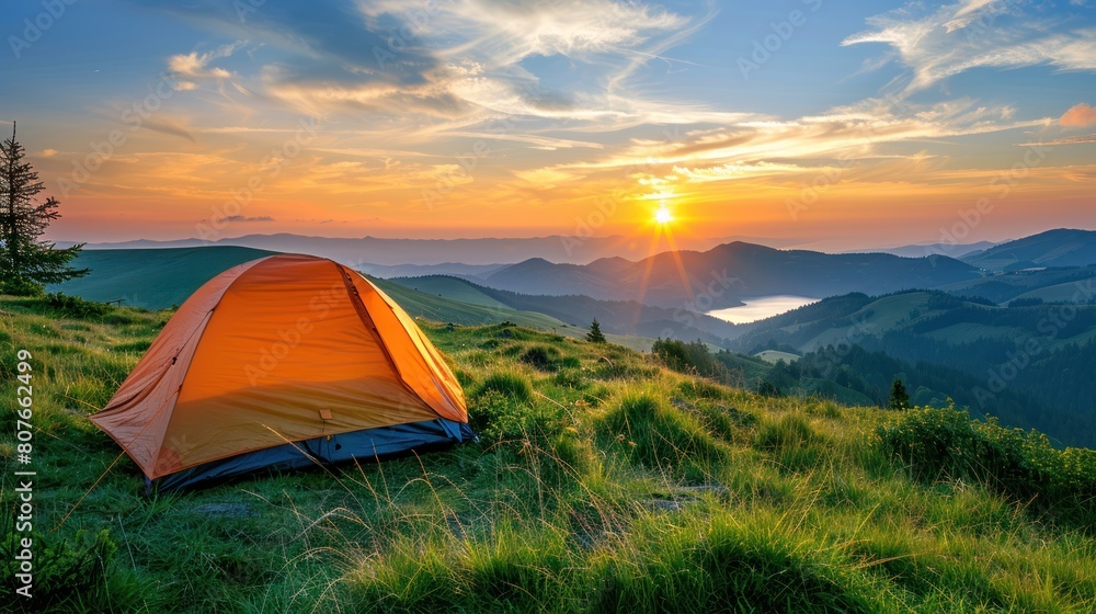 An orange tent pitched up on the peak of a mountain under clear skies