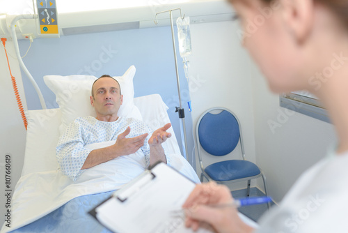anxious patient in hospital bed questioning nurse