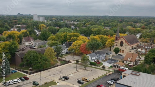 Aerial view of Green Bay Wisconsin autumn neighborhood with church in the foreground and Lambeau Field in the distance, drone push forward photo