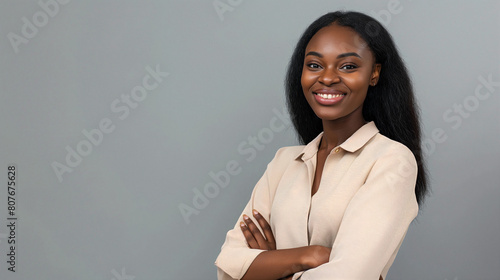 Heureuse jeune femme africaine, d'affaires professionnelle souriante et confiante portant une chemise beige, une femme cadre assez élégante regardant la caméra, debout, les bras croisés isolés sur fon photo