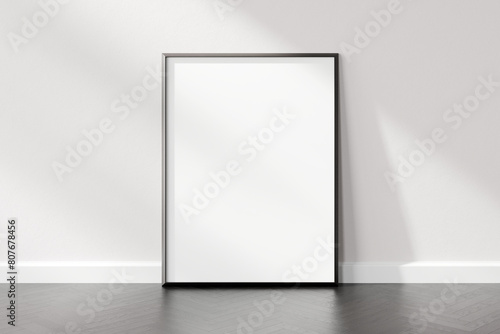 Blank white vertical poster frame standing against a white wall in a room with wooden flooring, casting a soft shadow, 3d render.