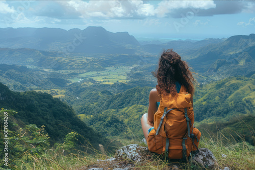 Solo traveler on a hilltop, gazing down at a lush mountain valley with blue sky above. AI generated.