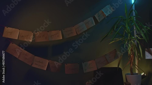 Wall with garland of notes. Stock footage. Notes on paper hang like garlands on wall. Ropes with sheets on wall photo