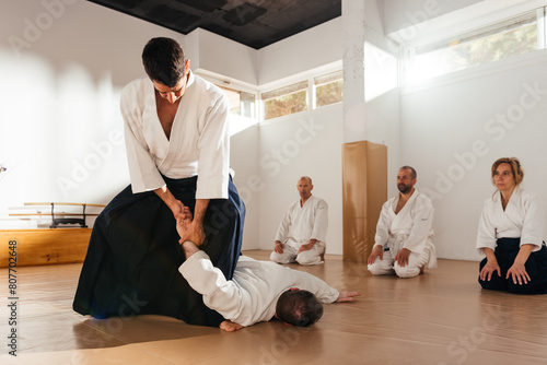 Martial Arts Sensei Demonstrating Wrist Lock Technique to Students in Dojo