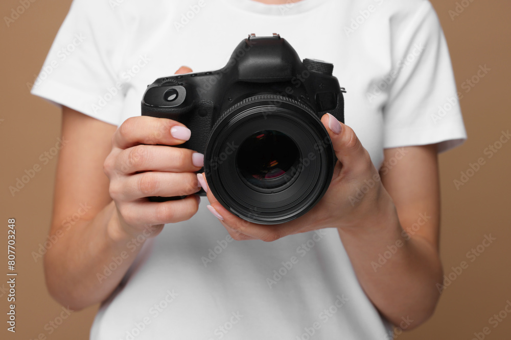 Photographer with camera on brown background, closeup