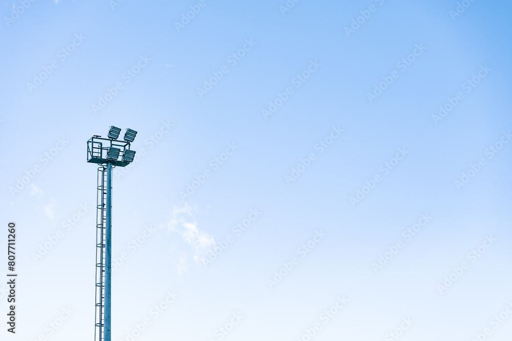 High floodlight tower against a clear blue sky High floodlight tower against a clear blue sky