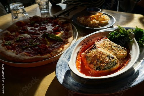 Close up Traditional Pepperoni and cheese Pizza served with cheesy eggplant and bread toast photo