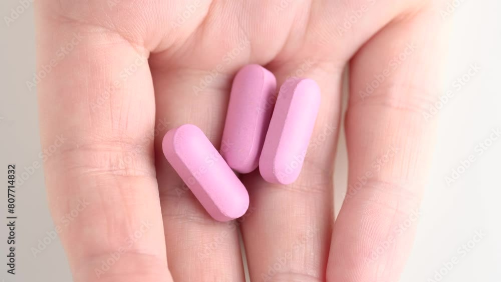 Close up shot of female hands showing pink pills or vitamins in the palm. Healthcare, treatment concept. Close up shot of female hands showing pink pills or vitamins in the palm. Healthcare, treatment concept.