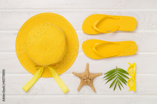 Flat lay with yellow summer outfit on wooden background. Vacation concept