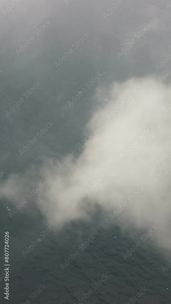 Drone flies over foggy and fluffy clouds. Aerial vertical view. Blue sky sun and sea fog. Abstract aerial nature summer ocean sunset sea and sky background. Vacation, vacation and holiday concept Drone flies over foggy and fluffy clouds. Aerial vertical view. Blue sky sun and sea fog. Abstract aerial nature summer ocean sunset sea and sky background. Vacation, vacation and holiday concept