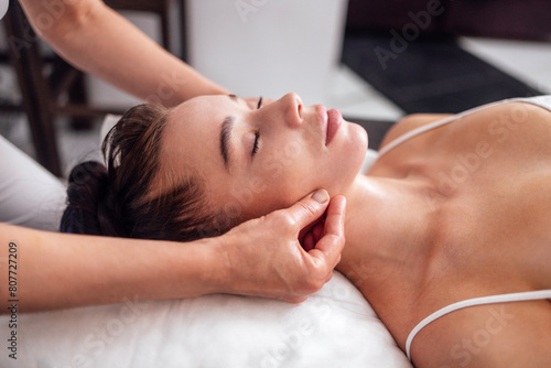 Brunette girl closed her eyes and enjoys a spa procedure in beauty salon
